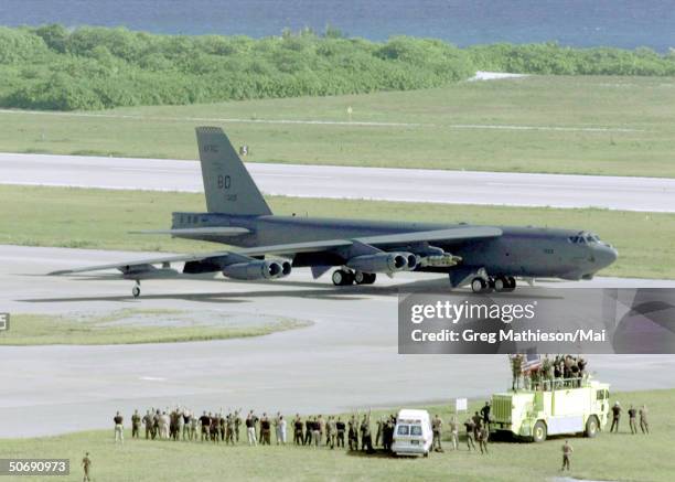 Ground crew members waving at a B-52H Stratofortress bomber as it taxis for take off on a strike mission against al Qaeda terrorist training camps...