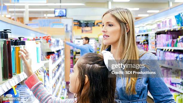 mother shopping for beauty products in supermarket with daughter - soap dispenser stock pictures, royalty-free photos & images