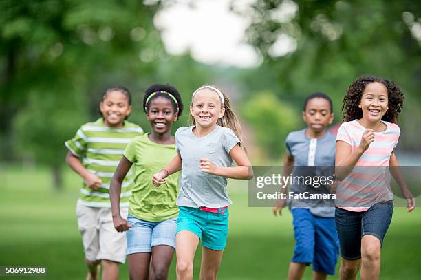 children running through the grass - family playing tag stock pictures, royalty-free photos & images