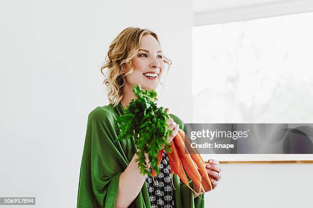 young woman with fresh carrots - carrot stock pictures, royalty-free photos & images
