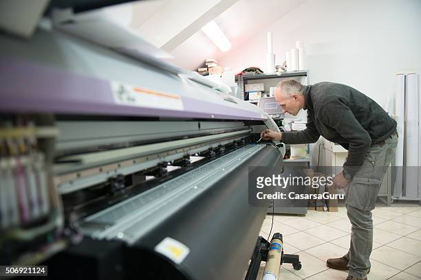 uomo pulizia stampante per grandi formati testa - digital printing foto e immagini stock