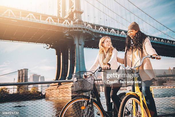 sharing a bicycle ride my friend in nyc - friends cycling stock pictures, royalty-free photos & images