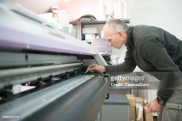man cleaning large format printer head - large printer stock pictures, royalty-free photos & images