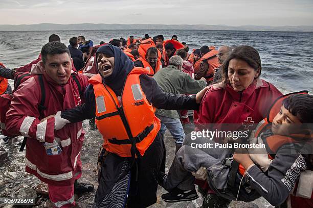 Refugees scramble over the rocks after another over crowded raft lands from Turkey on October 27 in Lesbos, Greece. Winter seas have done little to...