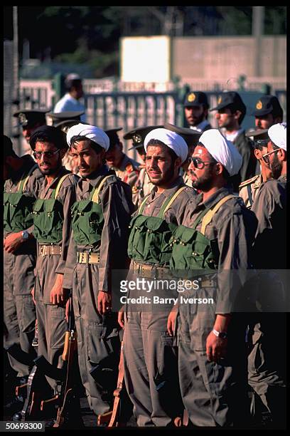 Revolutionary Guard soldiers incl. Basidjis, Islamic volunteers, in their midst leading troops marching in military parade kicking off sacred defense...