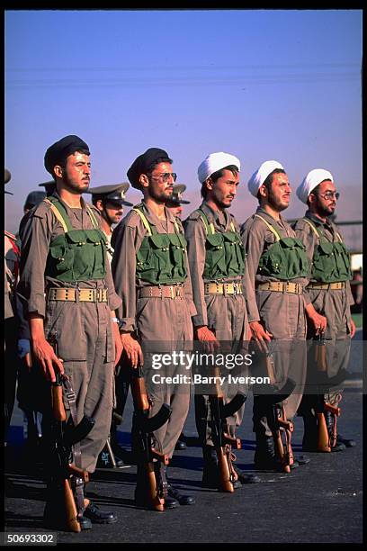 Revolutionary Guard soldiers incl. Basidjis, Islamic volunteers, in their midst leading troops marching in military parade kicking off sacred defense...