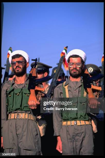 Revolutionary Guard soldiers incl. Basidjis, Islamic volunteers, in their midst leading troops marching in military parade kicking off sacred defense...