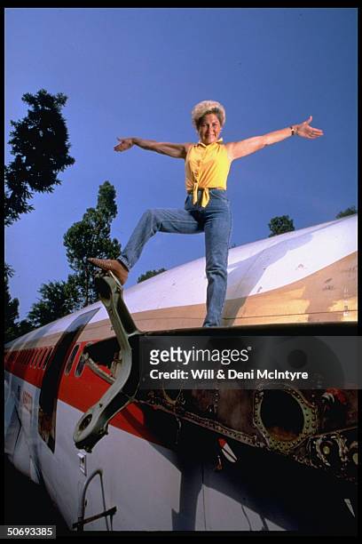 Jo Ann Ussery posing on Boeing 727 fuselage, which she converted into 3 bedroom home.