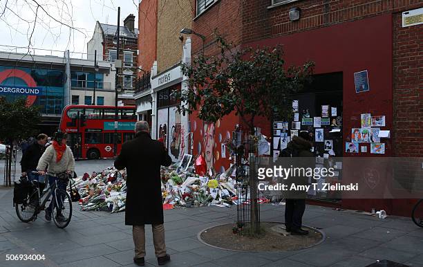 People pay their respects and photograph the flowers, letters and other items left on a mound continue to grow two weeks after the death of Brixton...