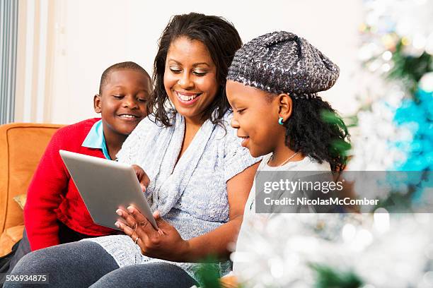 mom shows off her tablet at christmas - donate a photo holiday kick off event stock pictures, royalty-free photos & images