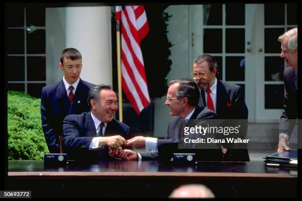 Presidents Nursultan Nazarbayev of Kazakhstan & George Bush exchanging pens during treaty signing ceremony outside White House.
