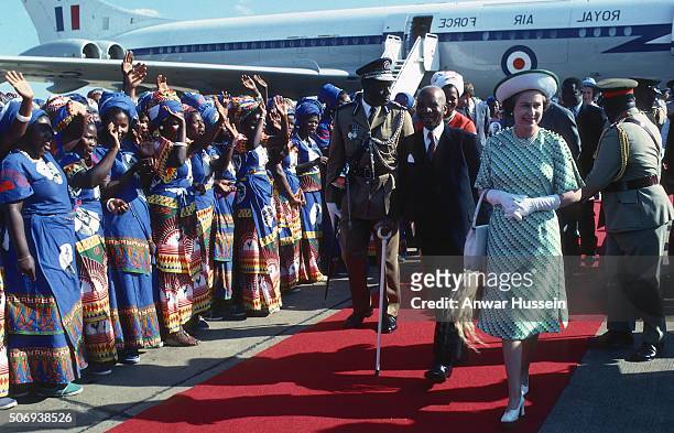 Queen Elizabeth ll is greeted by President Hastings Banda of Malawi as local ladies in traditional dress wave in welcome on July 01, 1979 in Malawi.
