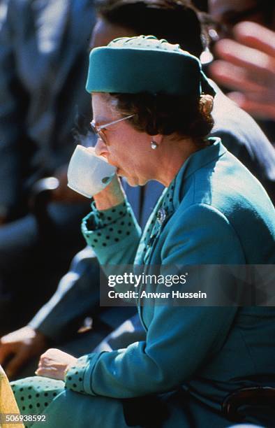 Queen Elizabeth ll enjoys a cup of tea as she attends an event circa January 01, 1985 in London, England.