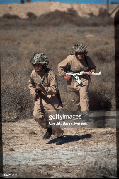 Women commando special force soldiers of Iranian resistance Mujahideen Khalq Natl. Liberation Army of Iran at run in combat exercise, camouflagic...