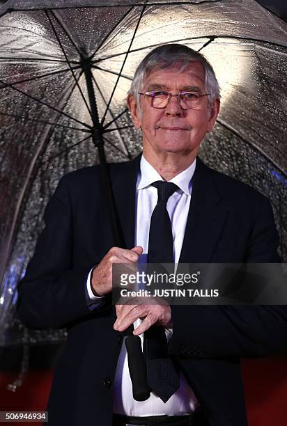 British actor Tom Courtenay shelters from the rain as she arrives for the world premiere of the film Dads Army in London on January 26, 2016. / AFP /...