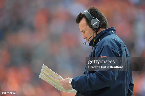 Head coach Gary Kubiak of the Denver Broncos consults his playbook in the AFC Championship game against the New England Patriots at Sports Authority...