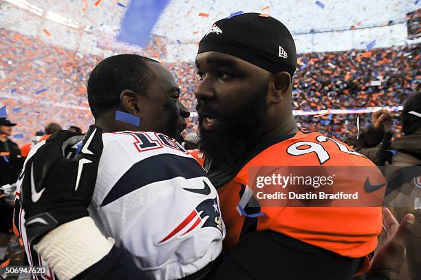 Sylvester Williams of the Denver Broncos and Matthew Slater of the New England Patriots embrace on the field after the AFC Championship game at...