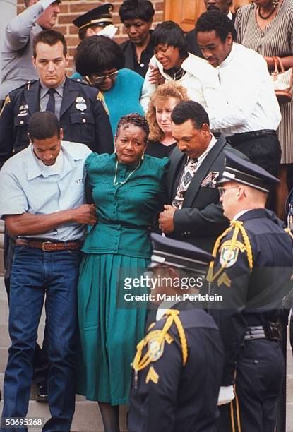 Leslie Yeakey holding arm of mother Almar Jarrahi as they leave funeral for his brother, Oklahoma City Police Officer Terry Yeakey, who committed...
