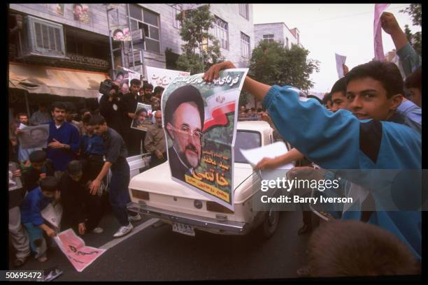 Young supporters of moderate cleric Mohammed Khatami w. Poster picturing presidential candidate during election campaign street rally.