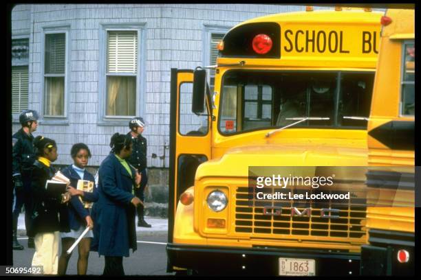 African-American students, being guarded by police, boarding school bus headed for newly integrated high school in South Boston.