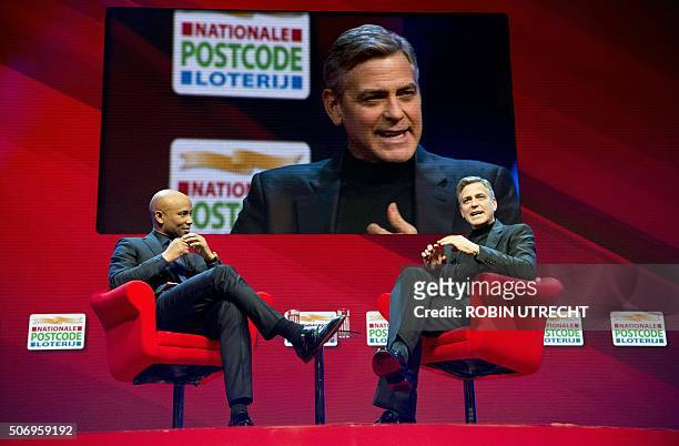 Dutch host Humberto Tan listens to US actor George Clooney during the Goed Geld Gala charity event at the Carre Theatre in Amsterdam on January 26,...