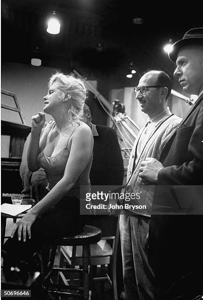 Actress Marilyn Monroe clenching her fist as she listens w. Anxiety to playback of her recording of My Heart Belongs to Daddy song which will be...