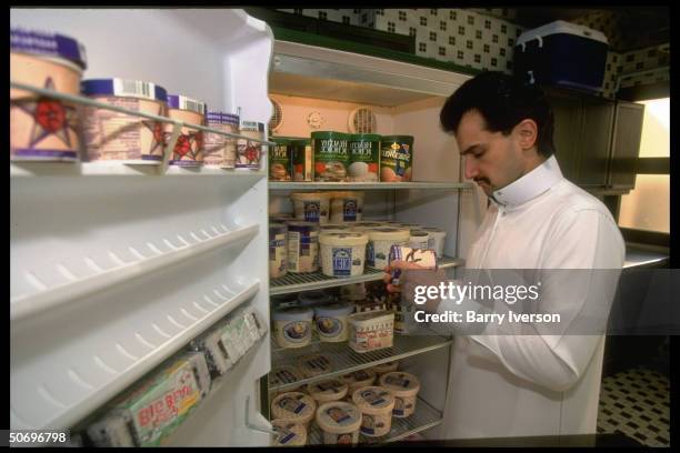 Billionaire investor Saudi Prince Alwaleed taking pint of low fat ice cream from his palace pantry freezer stocked w. US brands incl. Healthy Choice,...