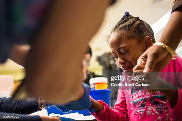 Tears stream down the face of Morgan Walker, age 5 of Flint, as she gets her finger pricked for a lead screening on January 26, 2016 at Eisenhower...