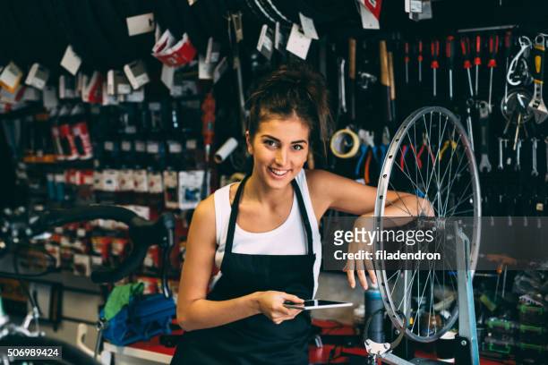 using a tablet while fixing a bicycle - bike ipad stock pictures, royalty-free photos & images