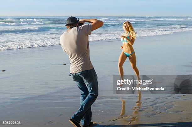 photographer and bikini model on the beach - beach model stock pictures, royalty-free photos & images