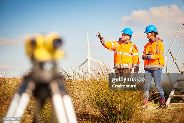 male and female windfarm engineers - male with spirit level stock pictures, royalty-free photos & images