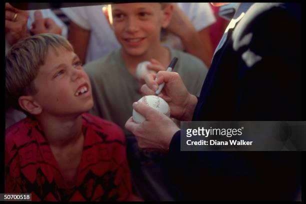 First Lady Hillary Rodham Clinton autographing baseball for young fan outside Baseball Hall of Fame in appearance opening her undeclared campaign for...