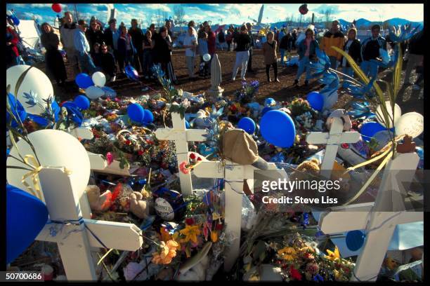 Flowers & tokens lad at makeshift memorial in remembrance of 13 victims killed by troubled seniors Dylan Klebold & Eric Harris who went on shooting...