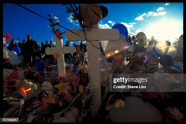 Flowers & tokens lad at makeshift memorial in remembrance of 13 victims killed by troubled seniors Dylan Klebold & Eric Harris who went on shooting...