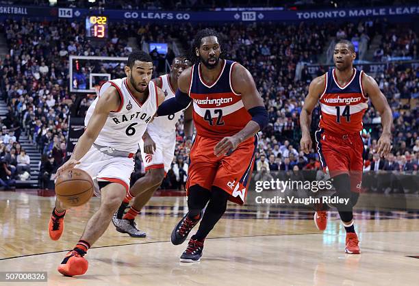 Cory Joseph of the Toronto Raptors dribbles the ball as Nene of the Washington Wizards defends during an NBA game at the Air Canada Centre on January...