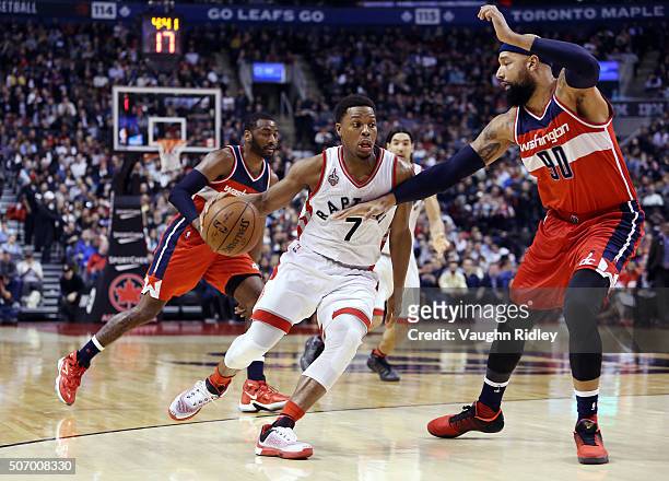 Kyle Lowry of the Toronto Raptors dribbles the ball as Drew Gooden of the Washington Wizards defends during an NBA game at the Air Canada Centre on...