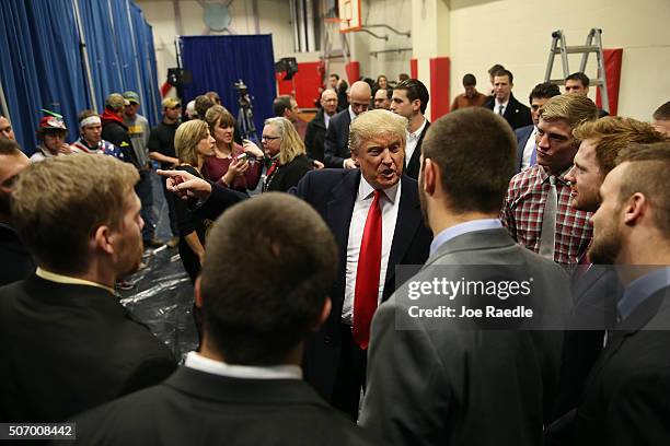 Republican presidential candidate Donald Trump talks with football players from the University of Iowa after they presented him with a football...