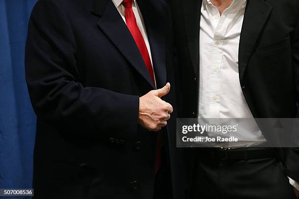 Republican presidential candidate Donald Trump flashes a thumbs up as he greets people during a campaign event at the University of Iowa on January...