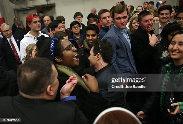 Protester is escorted out after interrupting a campaign event for Republican presidential candidate Donald Trump at the University of Iowa on January...