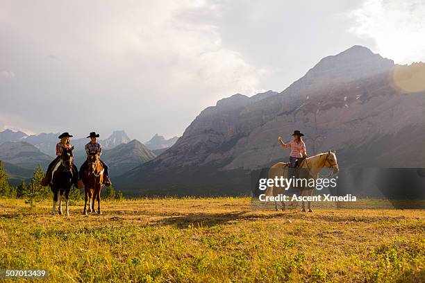 cowgirl takes smart phone pic of friends,mountains - recreational horseback riding stock pictures, royalty-free photos & images