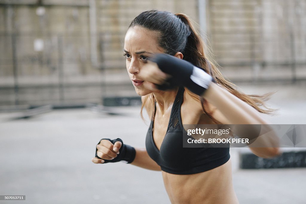 Young woman boxing in urban setting