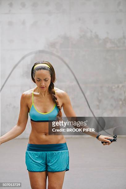 young woman jumping rope in urban setting - chignon stock pictures, royalty-free photos & images