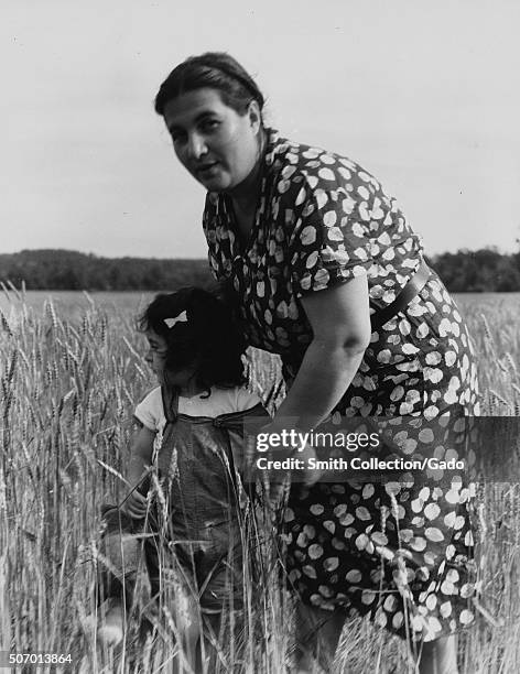 Jewish-American farm mother, Mrs Cohen, wife of the farm manager, with her daughter in a field of wheat, New Jersey, 1936. From the New York Public...