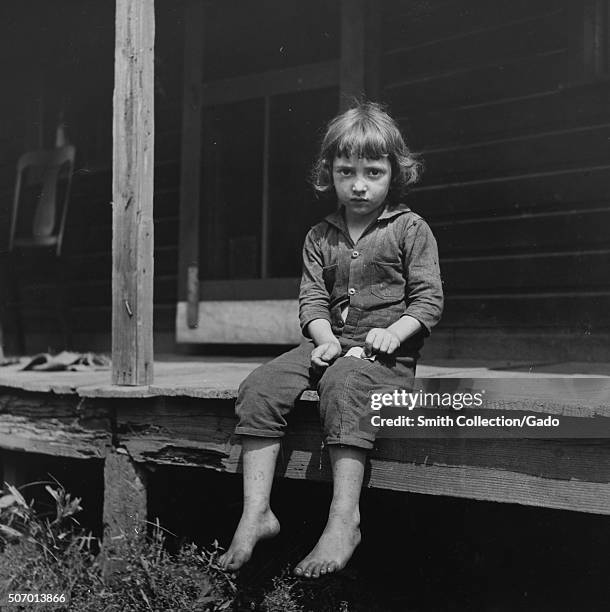 Child of coal miner sitting on porch, Jere, Scotts Run, West Virginia, 1938. From the New York Public Library. .