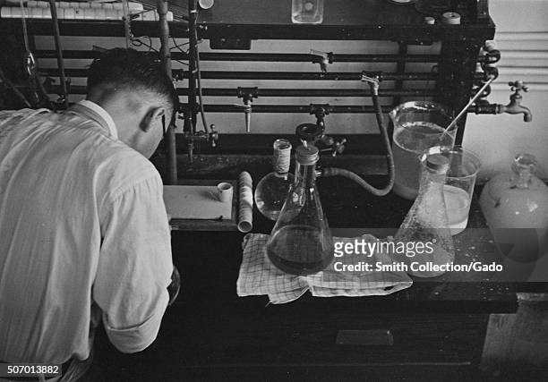 Scientist running experiments with flasks in a potato laboratory at the USDA, Beltsville, Maryland, 1935. From the New York Public Library. .