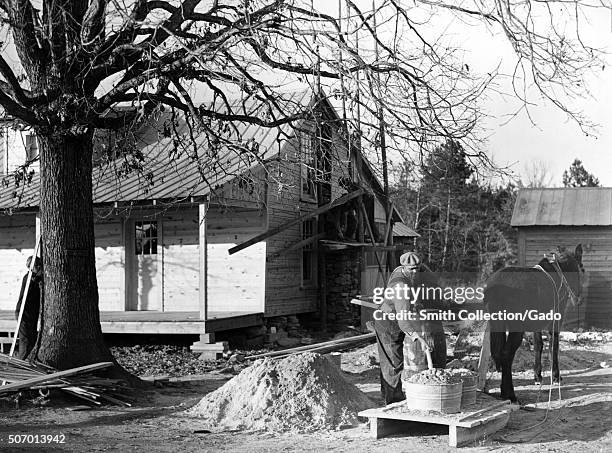 African-American Farm Security Administration rehabilitation client mixing cement to be used in construction of his new home, Raleigh, North...