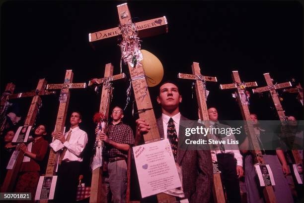 Participants in memorial for Cassie Bernall carrying 13 crosses in memory of Cassie & 12 other victims of last April's massacre at Columbine High...