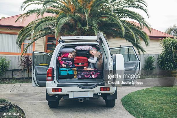children squashed into back of car with luggage - humor stockfoto's en -beelden