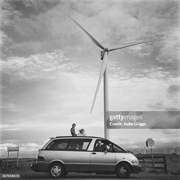 family in car parked beneath large wind turbine - australian family car fotografías e imágenes de stock