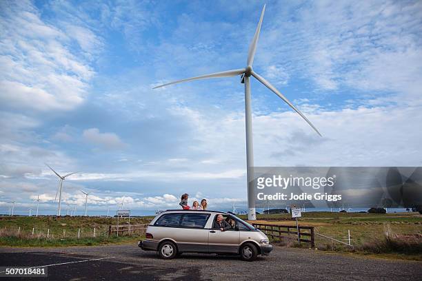 family in car parked beneath a large wind turbine - road trip australia stockfoto's en -beelden